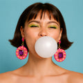 Woman blowing a bubble of gum against a blue background